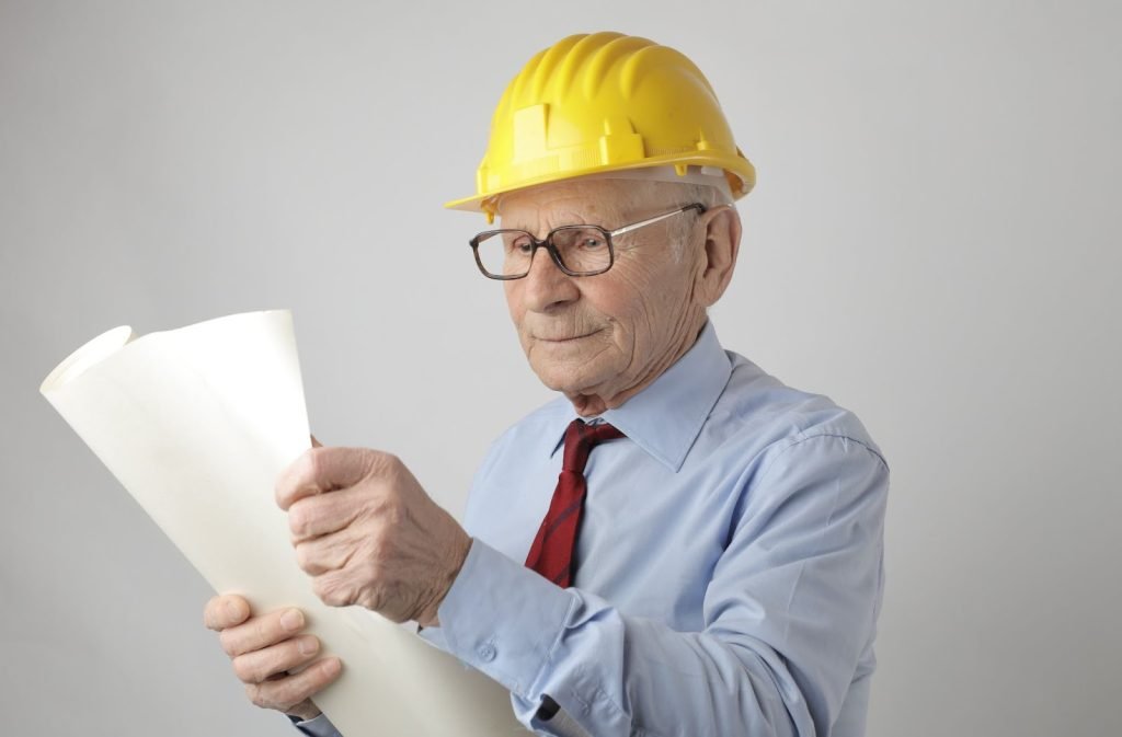 Senior male engineer reading blueprint in studio
