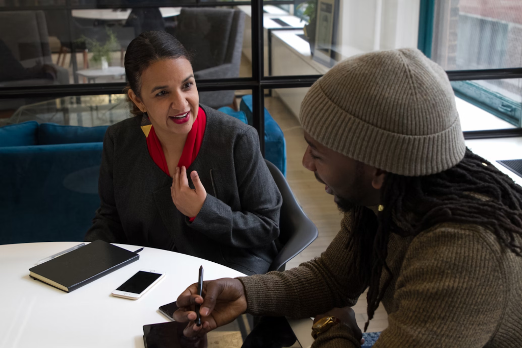 How To Boost Hiring Processes For Better Outcomes 5 a woman sitting at a table talking to another woman