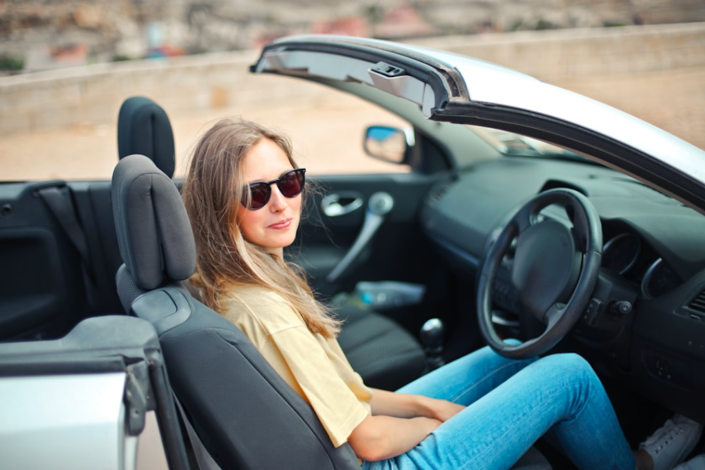 Guide To Buying A New Car: Key Considerations For Your Vehicle Purchase 3 smiling woman sitting on black and white vehicle