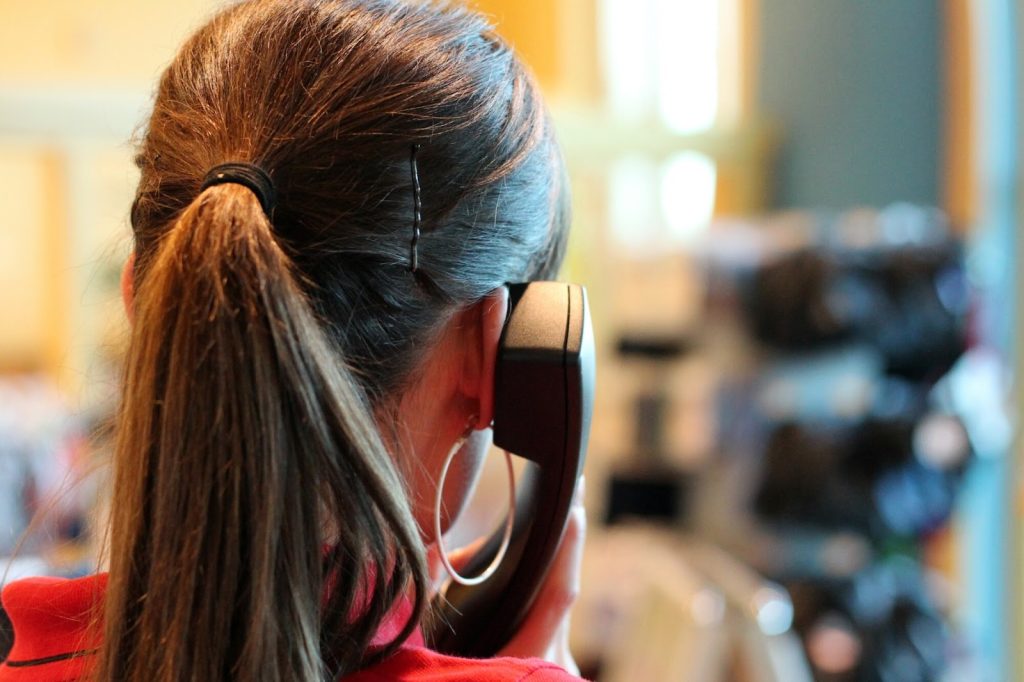 Choosing The Right Answering Service Provider: Key Considerations And Features 3 woman in red making phone call using desk phone