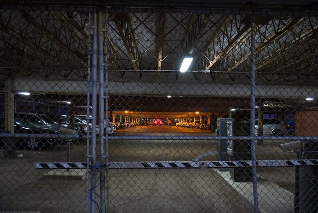 Car Storage Options For Collectors: Keeping Your Collection Safe 3 a parking garage with a chain link fence