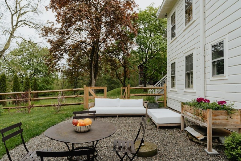 Designing Outdoor Retreats That Inspire Relaxation And Joy 1 a patio with a table and chairs and a couch